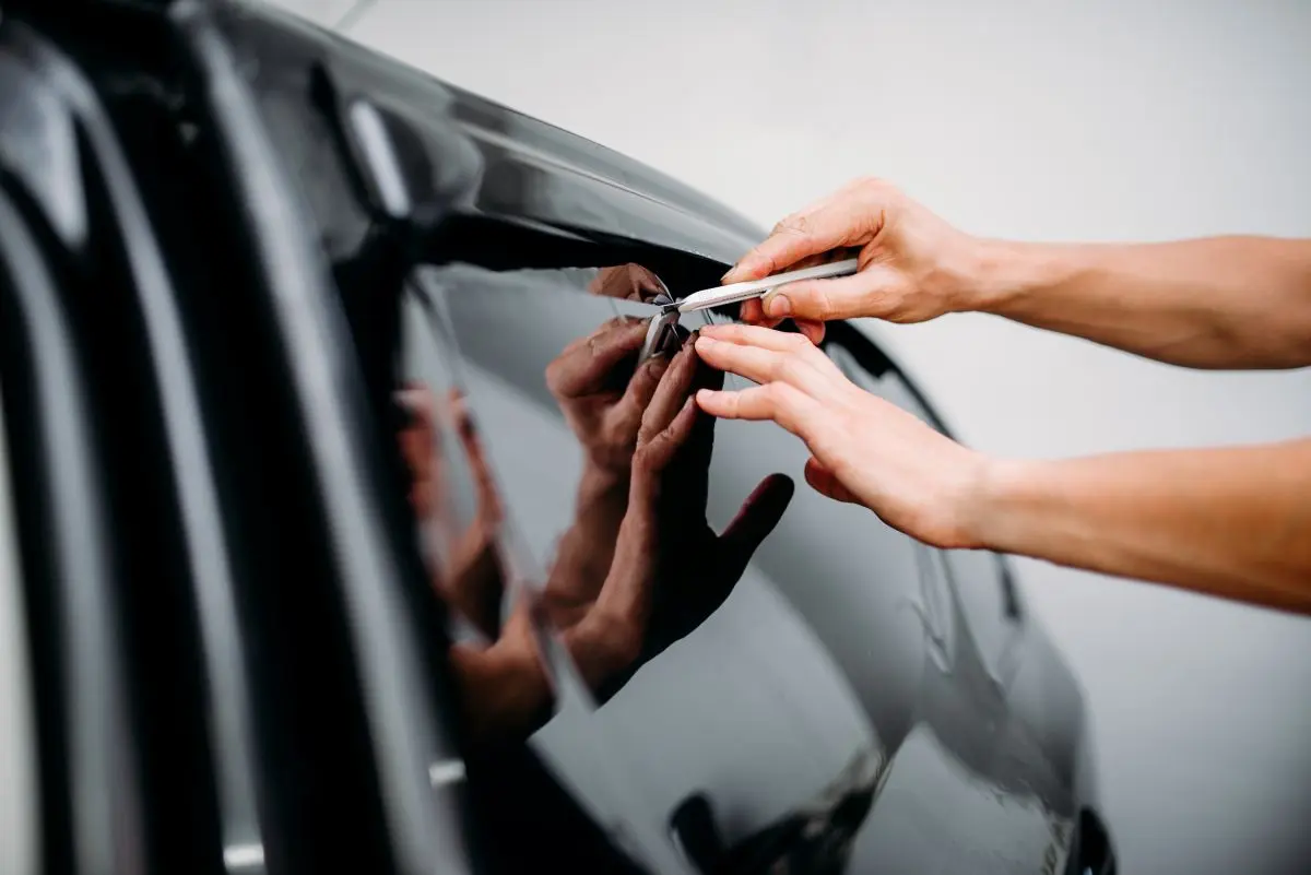 specialist work with car tinting film installing